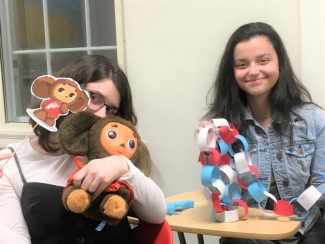 two students show off their decorations made for international coffee hour on feb. 15